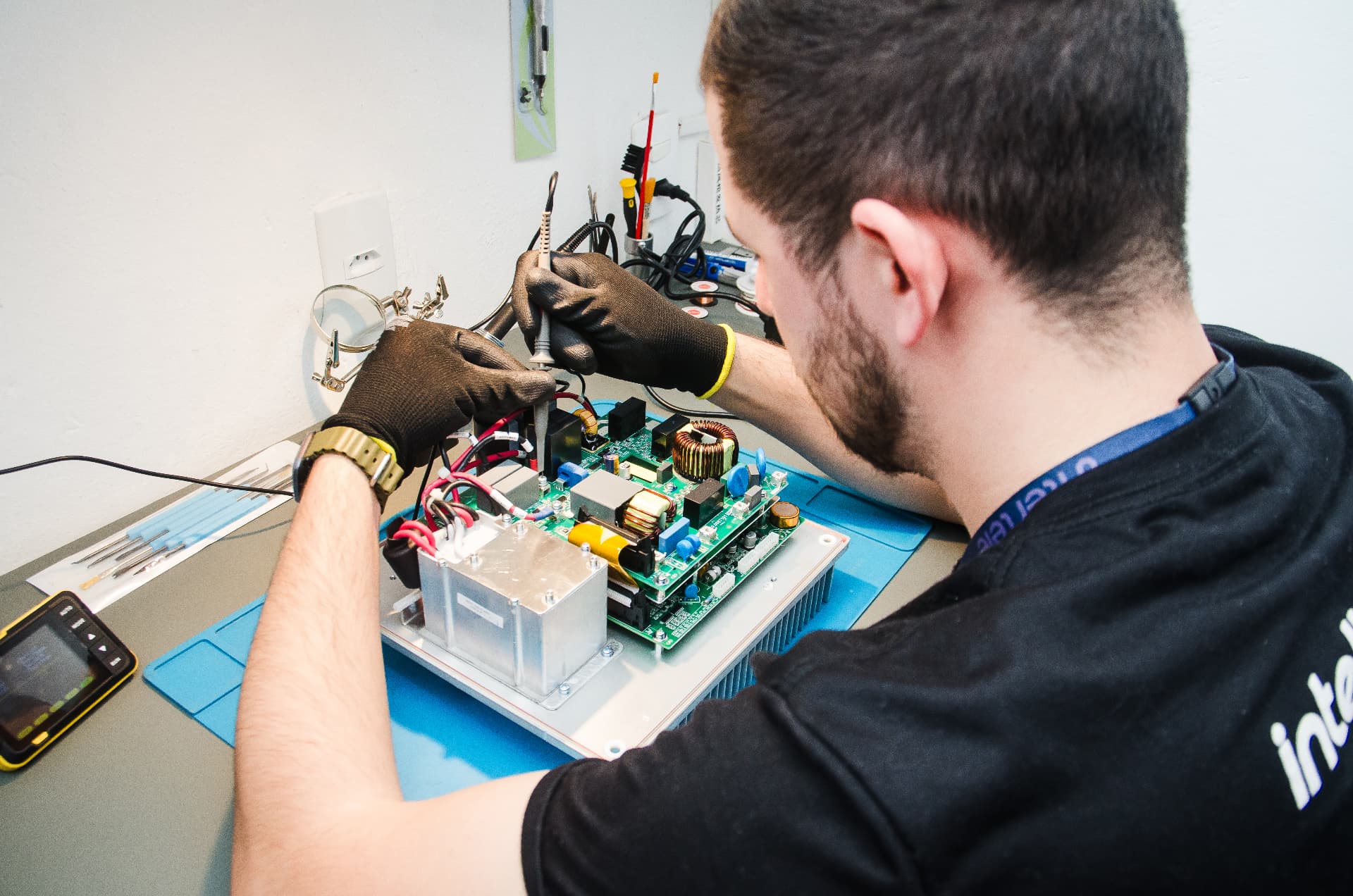 Técnico da Intertele realizando manutenção em placa de produto Intelbras